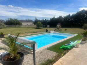 una piscina en un patio con un banco al lado en En apparté en Arles