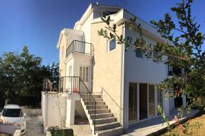 a white house with a staircase in front of it at Patrick House in Tivat