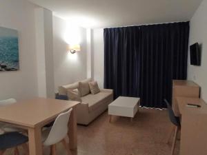 - un salon avec un canapé et une table dans l'établissement Apartamentos Orvay, à Sant Antoni de Portmany