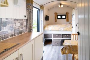 una cucina con un lavandino e un letto in una stanza di Shepherds hut with hot tub a Bodmin