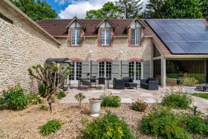 a house with solar panels on the roof at Appartement Élégant, Climatisation et Piscine in Ormoy-la-Rivière