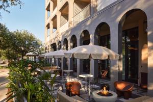 an outdoor patio with tables and chairs and a building at Hotel Henrietta in New Orleans