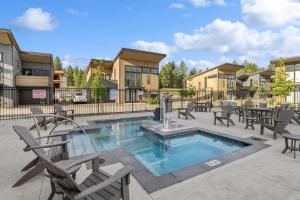 un patio avec des chaises et une piscine avec tables et chaises dans l'établissement Quarry A25, à Whitefish