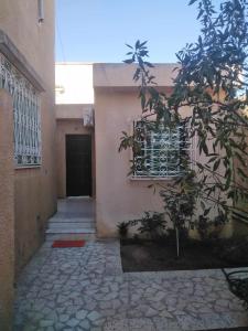 a building with a window and a tree in front of it at Charmante Maisonnette avec Jardin et arbis voiture in Ez Zahra