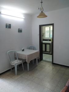 a room with a table and two chairs and a kitchen at Charmante Maisonnette avec Jardin et arbis voiture in Ez Zahra