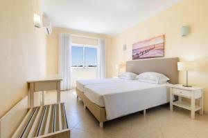 a bedroom with a large white bed and a window at Vila Marachique Torralvor in Alvor +66 photos