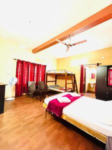 Schlafzimmer mit einem Bett, einem Schreibtisch und einem Tisch in der Unterkunft Sahyadri Homestay wayanad in Kalpatta