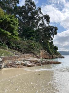 a stairway to the beach with trees and the water at COSTA MARIÑA Fabuloso apartamento en la costa in O Vicedo