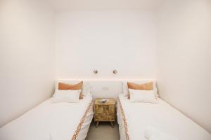 two beds in a room with white walls at Apartamento de tres habitaciones en Girona in Girona