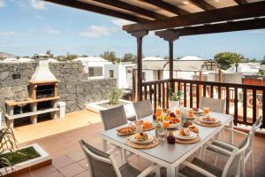 einen Tisch mit Speisen auf einem Balkon mit Kamin in der Unterkunft Villa 61 PlayaBlanca Lanzarote Pool Spa in Playa Blanca