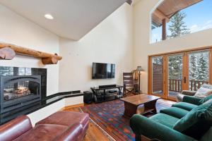 Silvertip Ski Haus في وايتفيش: غرفة معيشة مع أريكة ومدفأة