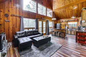 een woonkamer met een leren bank en een keuken bij Modern Black Hills Cabin with Loft and Wraparound Deck in Rapid City