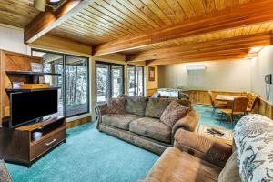 een woonkamer met een bank en een televisie bij Modern Black Hills Cabin with Loft and Wraparound Deck in Rapid City