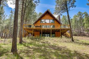 een huis in het bos met een terras rondom bij Modern Black Hills Cabin with Loft and Wraparound Deck in Rapid City