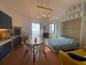a kitchen and dining room with a table and a bed at WildSunset in Monte Argentario