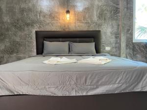 Una cama con dos toallas encima. en Green Mountain Resort Koh Yao en Ko Yao Yai