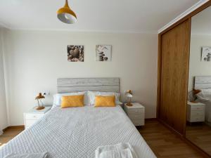 a bedroom with a large bed with orange pillows at COSTA MARIÑA Fabuloso apartamento en la costa in O Vicedo
