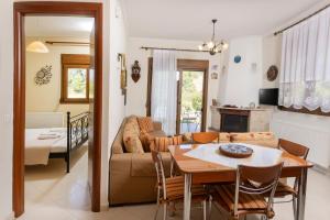a living room with a table and a couch at The Emerald Garden Maisonette in Siviri