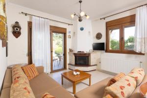 a living room with a couch and a fireplace at The Emerald Garden Maisonette in Siviri
