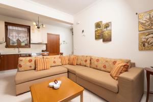 a living room with a couch and a table at The Emerald Garden Maisonette in Siviri