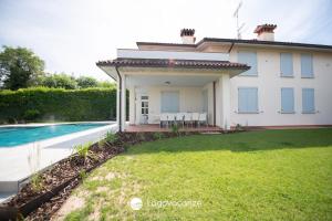 a house with a swimming pool and a yard at Exclusive Villa le Palme in Polpenazze del Garda