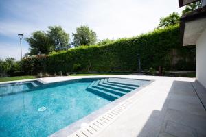 a swimming pool in the middle of a yard at Exclusive Villa le Palme in Polpenazze del Garda