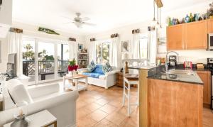 a kitchen and living room with a couch and a table at Pineapple Fields in Governorʼs Harbour