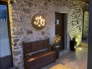 La Casassa de Ribes في ريب دي فريزر: مقعد أمام جدار حجري مع علامة