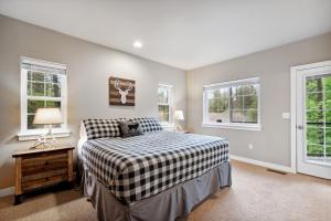 a bedroom with a bed and two windows at Suncrest Hideaway in Whitefish