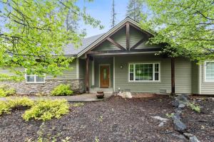 a green house with a cat sitting in the front yard at Suncrest Hideaway in Whitefish