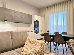 ein Wohnzimmer mit einer Couch und einem Tisch mit Stühlen in der Unterkunft Corso Italia Executive Suite in Arezzo