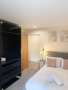 1 dormitorio con 1 cama blanca grande y piano en Spacious 1BR in Romford - Near Elizabeth Line, en Romford