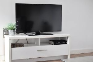 un centro de entretenimiento blanco con televisión. en Spacious 1BR in Romford - Near Elizabeth Line, en Romford 8 fotos más