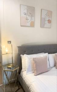 Un dormitorio con una cama y una mesita de noche. en Spacious 1BR in Romford - Near Elizabeth Line, en Romford