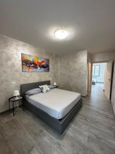 1 dormitorio con 1 cama y una pintura en la pared en Villa 2 en Cassano dʼAdda