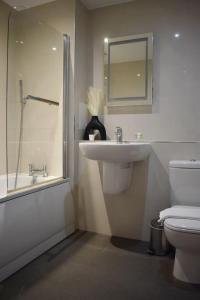 a bathroom with a sink and a toilet and a shower at Stylish 2BR - 1 minute walk from Elizabeth Line in Romford