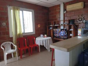 eine Küche mit zwei roten Stühlen und einem Tisch mit in der Unterkunft A orillas del paraiso in Playas