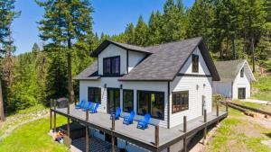 een tiny house met blauwe stoelen op een steiger bij Wilderness Retreat in Creston