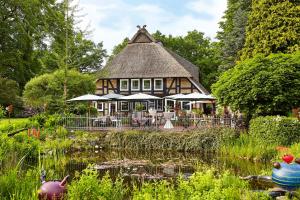 una casa grande con un estanque frente a ella en Romantik Hotel Köllners Landhaus en Celle