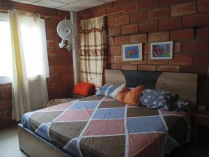 - une chambre avec un lit et un mur en briques dans l'établissement A orillas del paraiso, à Playas