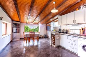 Una cocina con gabinetes blancos y una mesa con sillas. en Refúgio do Lourinho, en Funchal
