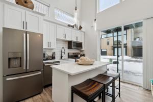 a kitchen with white cabinets and a counter with stools at Quarry A35 in Whitefish
