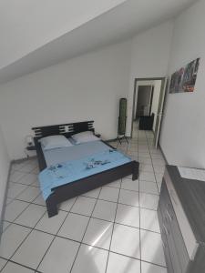 a bedroom with a bed and a tiled floor at Appartement en Duplex, centre ville de Saint Leu, résidence privée in Saint-Leu +4 photos