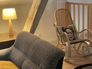 uma cadeira de baloiço com um cobertor sobre ela num quarto em La grange de Sophie em Berstett