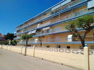 an apartment building with a fence in front of it at Las perlas VYBDenia in Denia