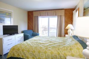 a hotel room with a bed and a television at Ocean Pines Resort by Capital Vacations in Duck