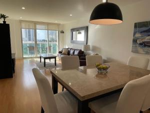 阳光岛滩Stunning apt! Oceanview! Parking included的带桌椅和沙发的客厅