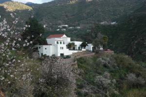 a white house on the side of a mountain at Alojamiento Rural La Montaña in Tejeda