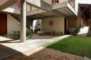 a patio of a building with a table and a bench at Loft Vila Murici in Flecheiras +35 photos
