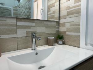 a white sink in a bathroom with a mirror at B&B Sensorial Experience in Villamassargia